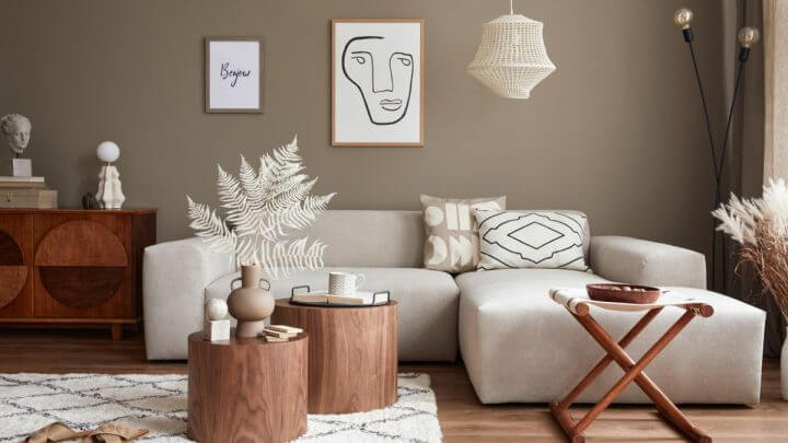 Sala de estar com sofá branco, mesa de centro e quadros na parede