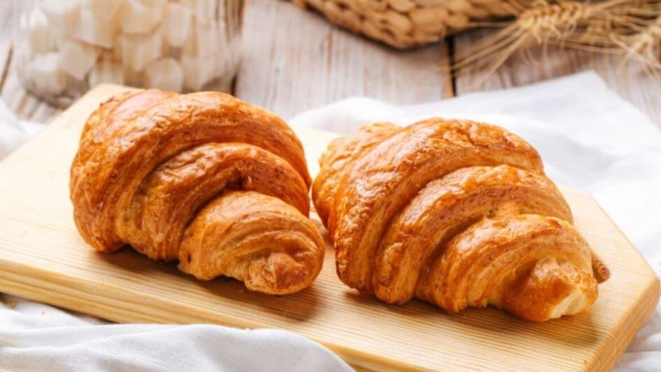 Dois croissant em cima de uma tábua de madeira