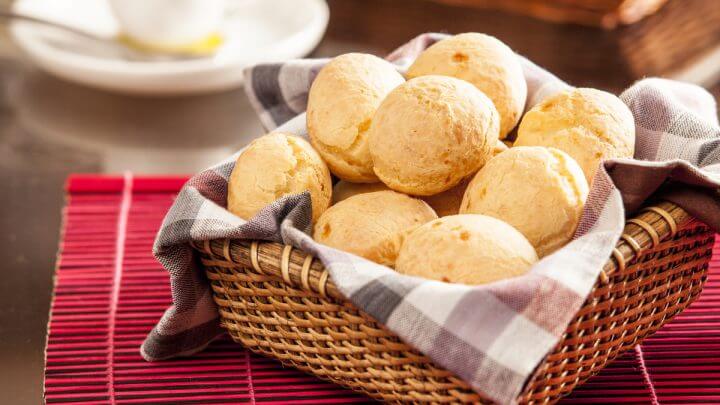 Pães de queijo numa cesta com pano vermelho