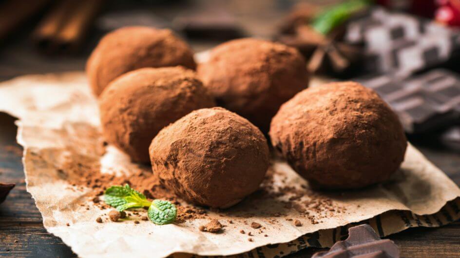 Trufas cobertas por cacau em pó em cima de papel