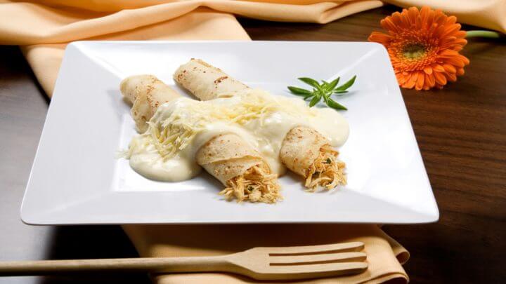 Duas panquecas de frango com molho branco em cima do prato