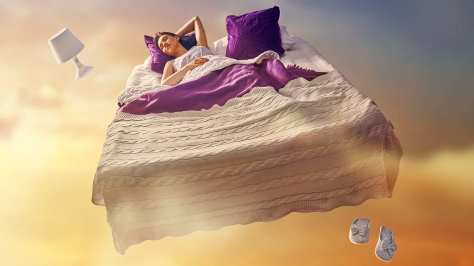 Mulher dormindo em uma cama flutuando no céu