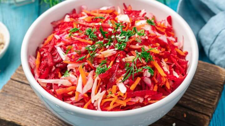 Salada com beterraba, cenoura e repolho em um recipiente branco