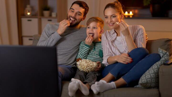 Família assistindo a um filme comendo pipoca