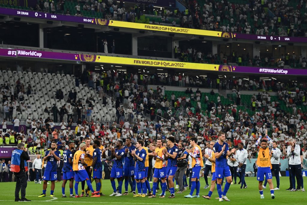 Jogadores dos Estados Unidos comemoram classificação sobre o Irã com os torcedores no estádio