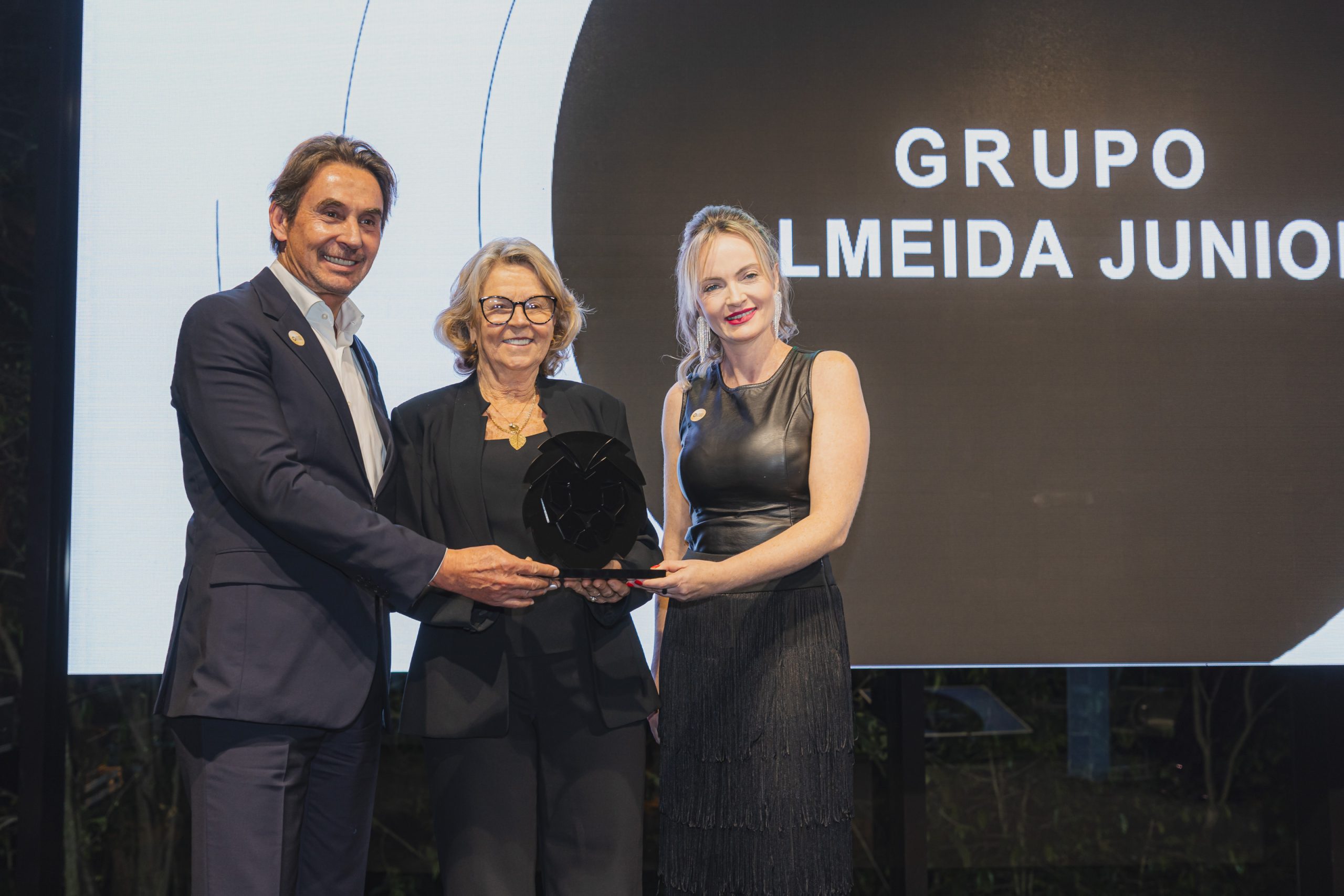 Jaimes Almeida Junior (CEO AJ) e Beth Rachelle (diretora de Gente e Gestão da Almeida Junior) recebem o prêmio de Alice Kuerten (representando o LIDE), ao centro na foto