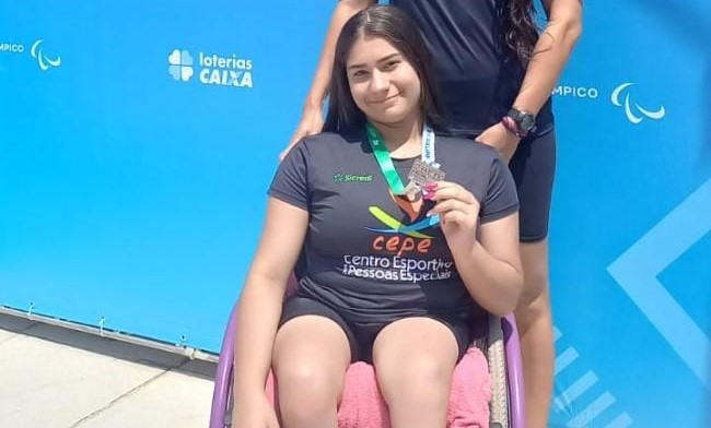 Paratleta Giovana Cristina posando com a medalha de bronze no Meeting Paralímpico de Natação