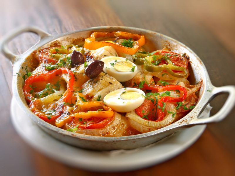 Bacalhoada com pimentões, ovos, azeitona e cebola dentro do bowl prata
