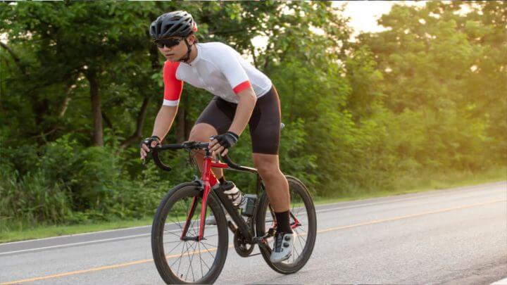 Homem com roupa de ciclista andando de bicicleta