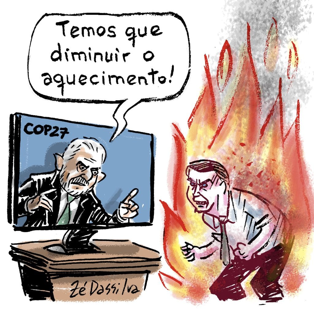 Na imagem vemos Lula na televisão dizendo "temos que diminiur o aquecimento!". Bolsonaro aparece ao lado em chamas assistindo a televisão.