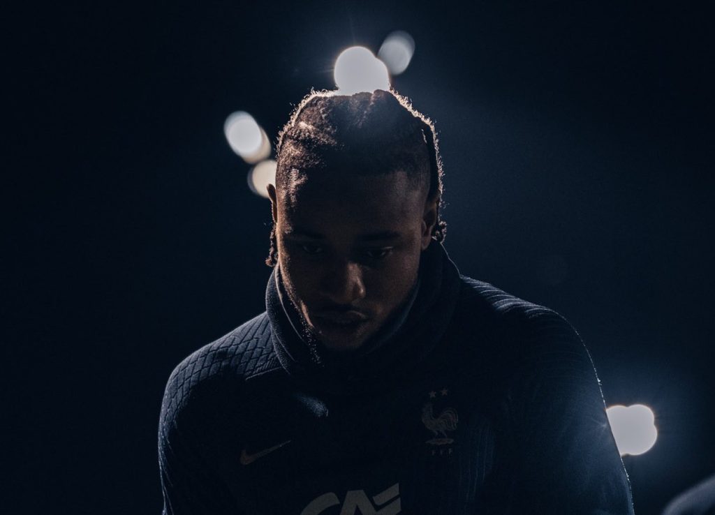 Christopher Nkuku de cabeça baixa com o uniforme de treino da Seleção da França