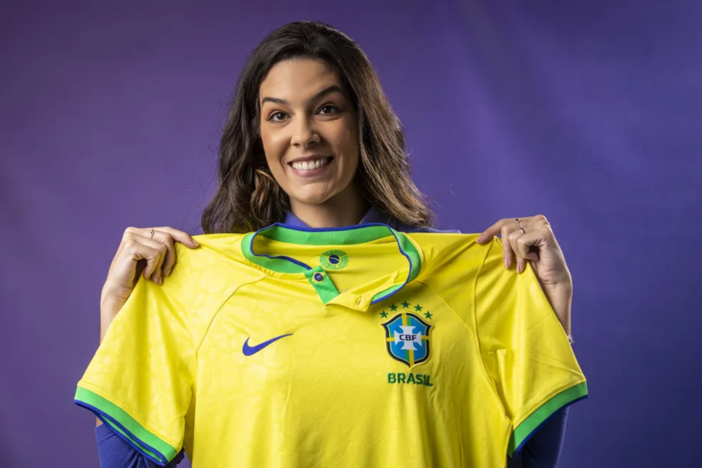 Narradora Renata Silveira segura camisa da Seleção Brasileira