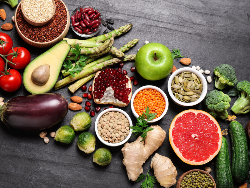 Diversos alimentos saudáveis em cima da mesa cinza
