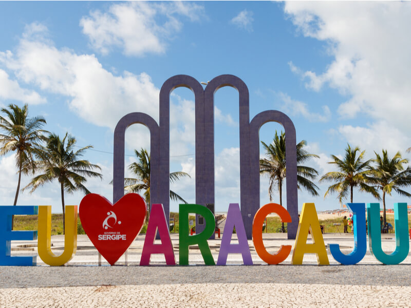 Letreiro de Aracaju na orla e coqueiros ao fundo