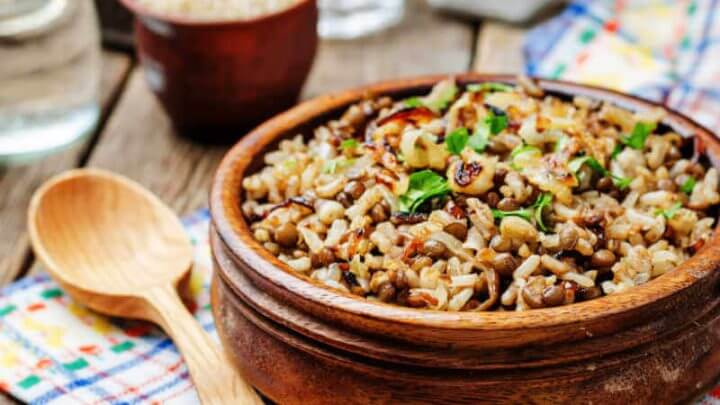 Arroz com lentilha e cebola caramelizada dentro do bowl marrom