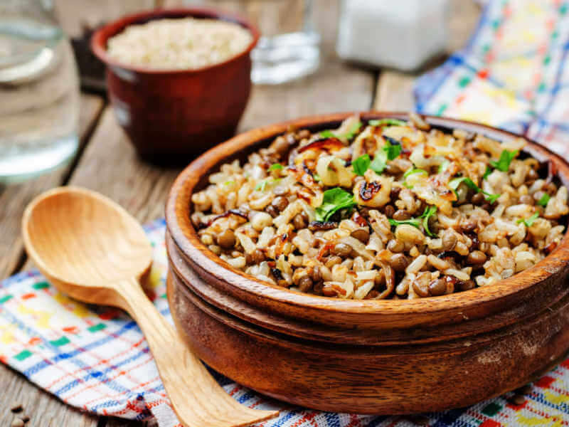 Arroz com lentilha e cebola caramelizada dentro do bowl marrom