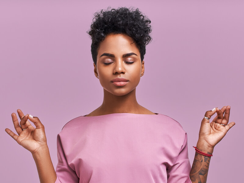 Mulher meditando no fundo lilás