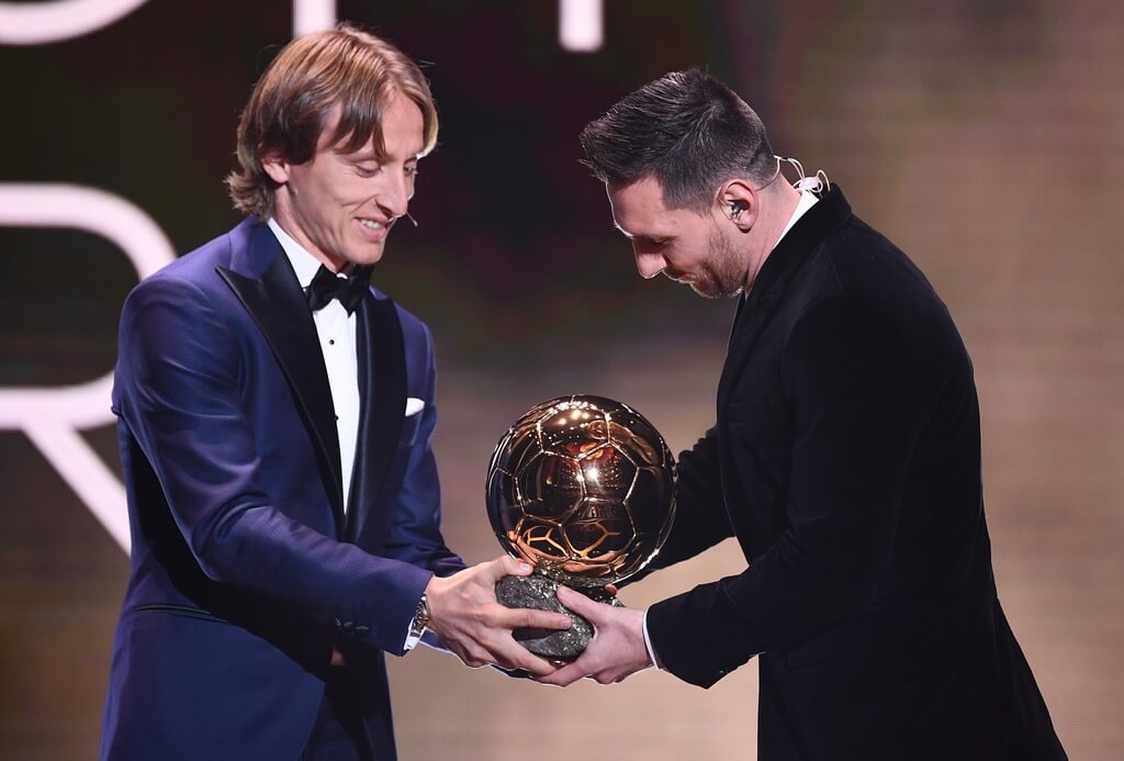 Luka Modric entregando bola de ouro para Lionel Messi em 2019