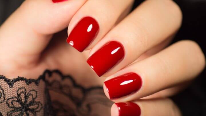 Mão com unha pintada de vermelho