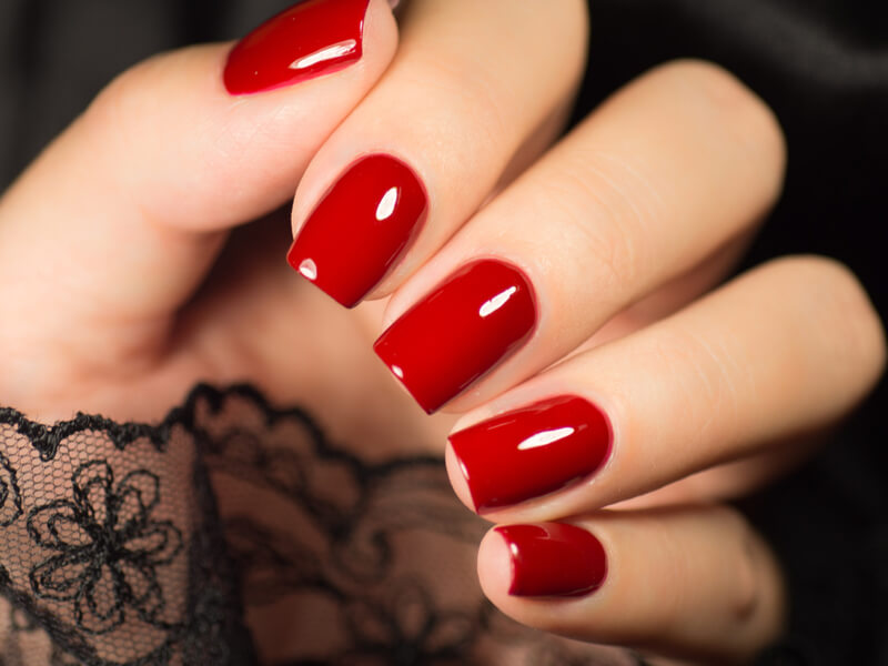 Mão com unha pintada de vermelho