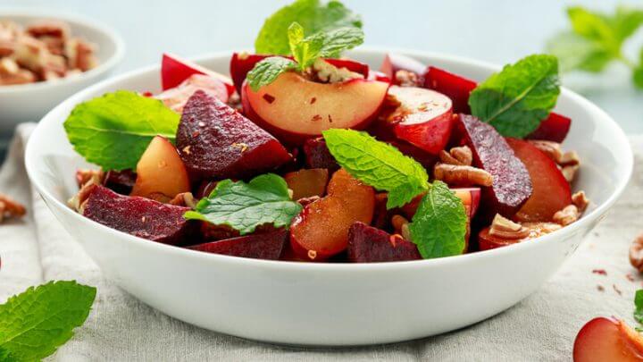 Salada de ameixa, beterraba e com folhas de hortelã no bowl branco