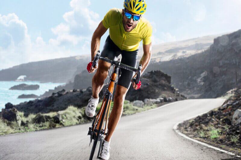 Ciclista de óculos de sol e capacete andando de bicicleta