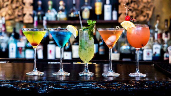 Taças com bebidas coloridas em cima de um balcão