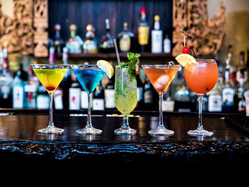 Taças com bebidas coloridas em cima de um balcão
