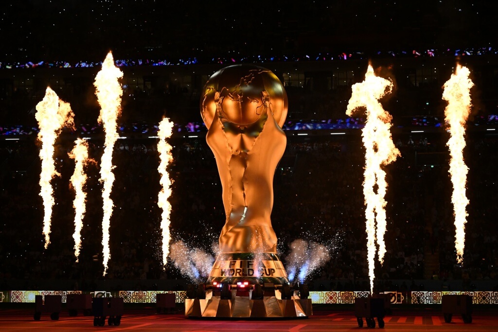 Réplica inflável da taça da Copa do Mundo na cerimônia de abertura do evento, com fogo atrás