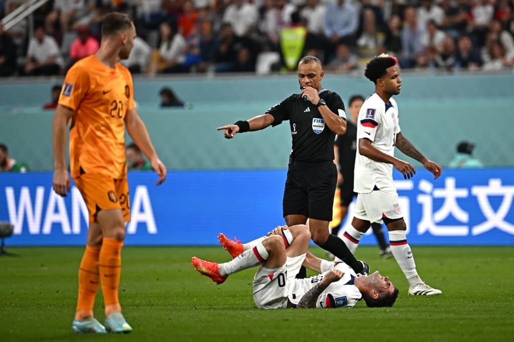 Wilton Pereira Sampaio apitando uma falta em Holanda x Estados Unidos nas oitavas de final da Copa do Mundo