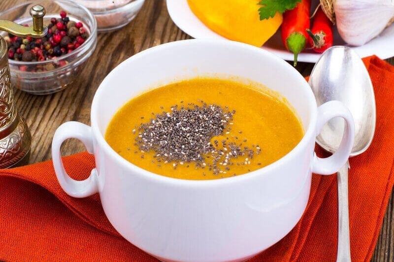 Creme de abóbora em uma panela branca com sementes de chia