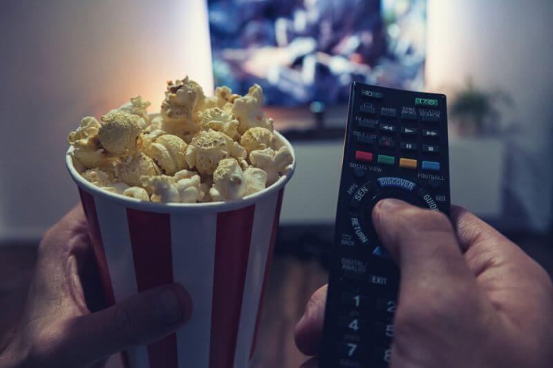 Uma pessoa com pipoca e controle na mão