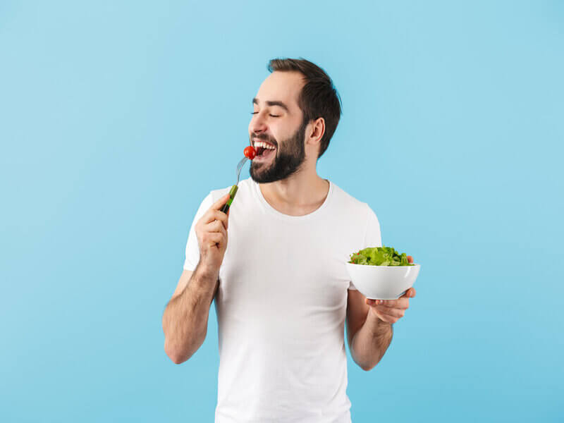 Comendo de blusa branca comendo salada