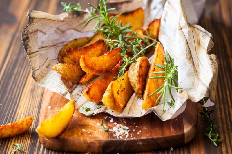 Batatas rústicas em cima de uma tábua de madeira