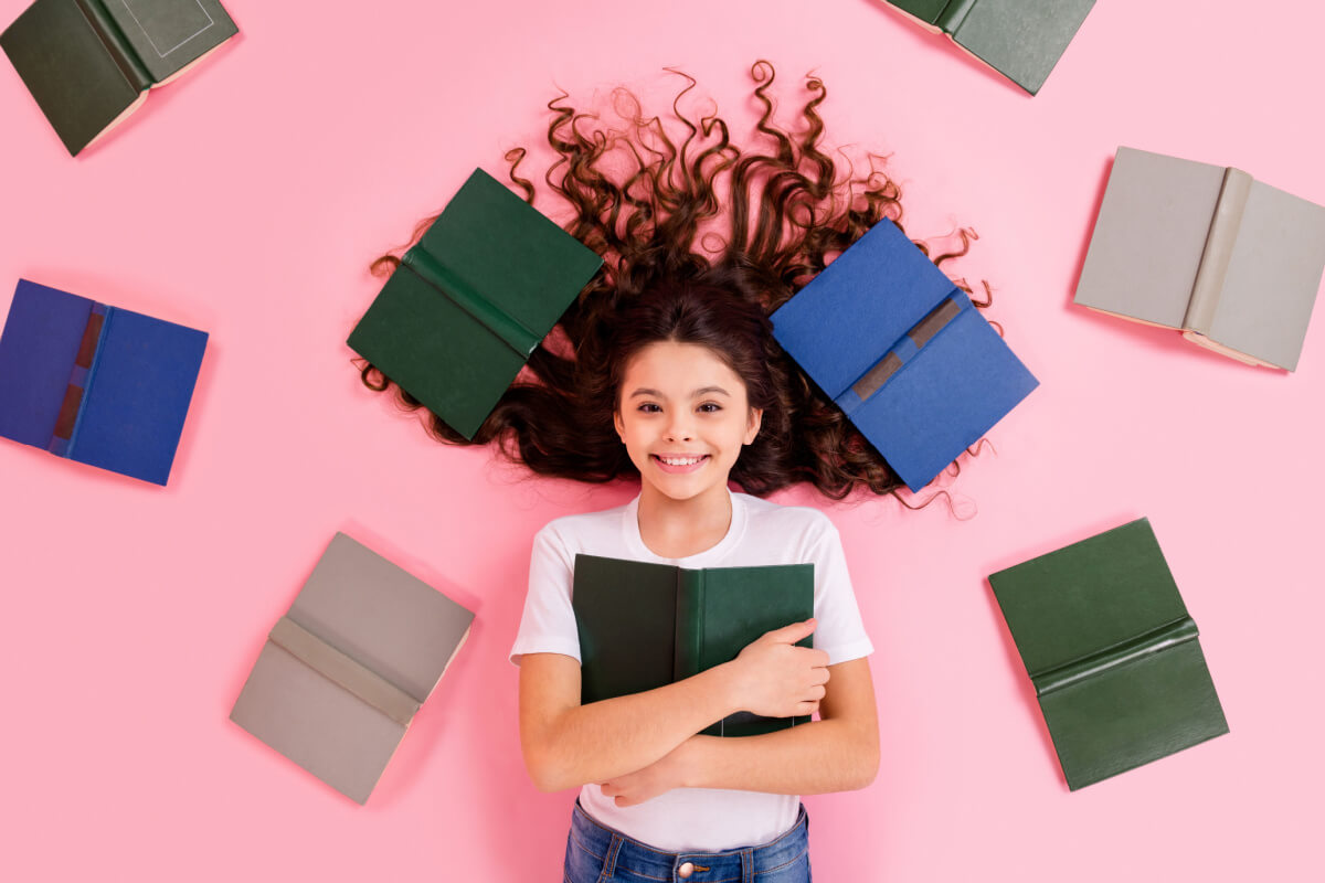 Garota abraçando livro e vários outros ao seu redor