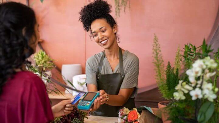 Florista atendendo cliente e recebendo pagamento
