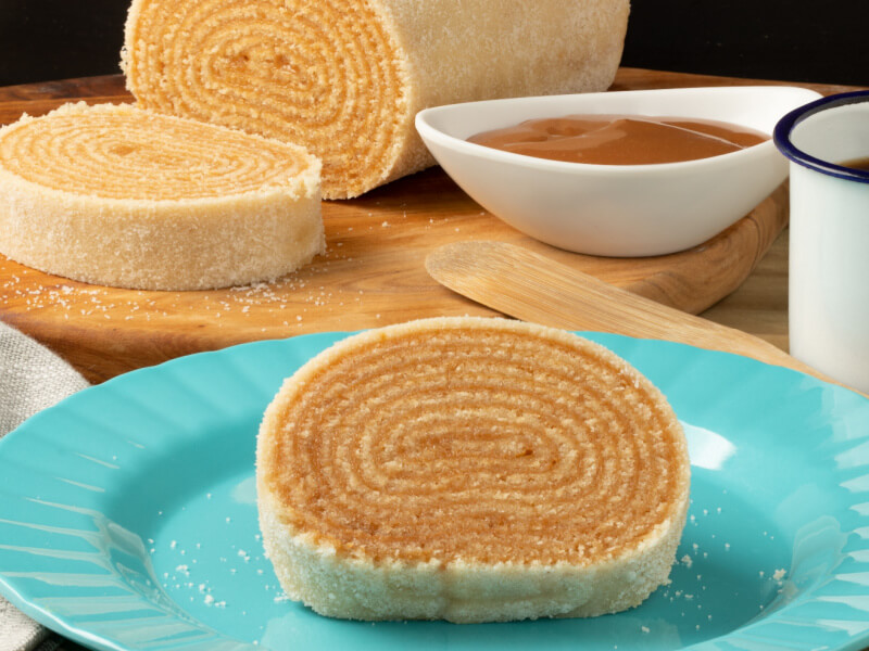 Fatia de bolo de rolo em prato azul