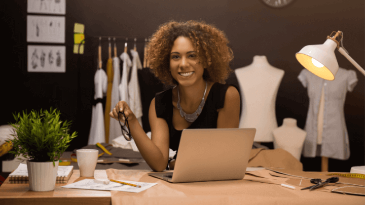 Jovem empresária e designer de moda trabalhando em seu ateliê