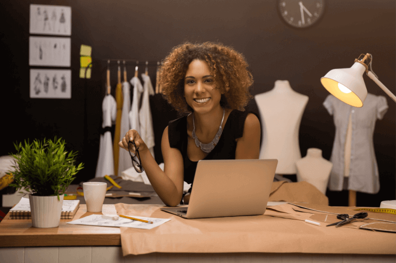 Jovem empresária e designer de moda trabalhando em seu ateliê