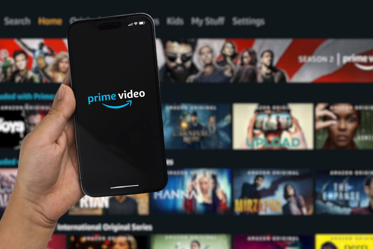 Garoto segurando um iPhone 14 Pro com o aplicativo de Prime Video
