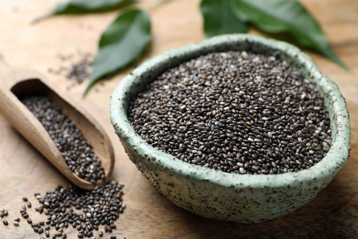 Bowl cheio com sementes de chia e sementes espalhadas ao lado