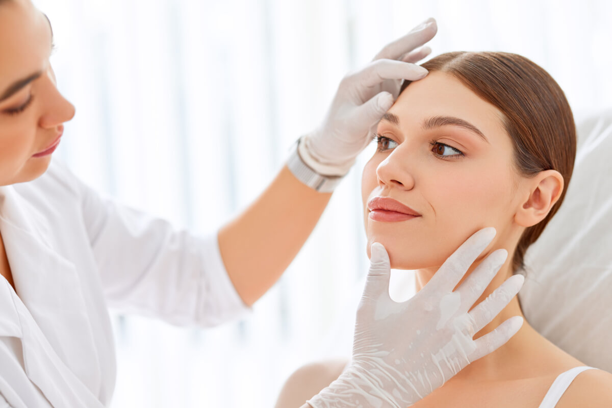Médica dermatologista examinando rosto de paciente