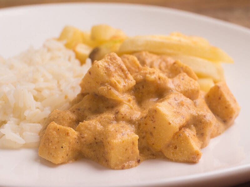 Estrofonofe de palmito em um prato branco com arroz e batata-frita