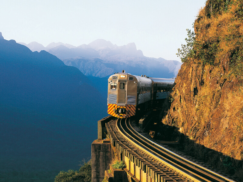 Trem em linha com montanhas ao fundo