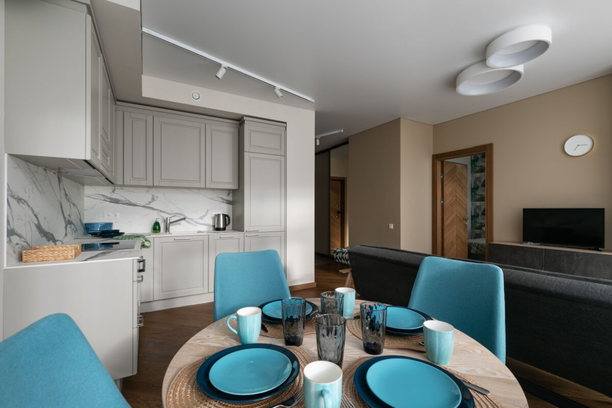 Interior de uma sala de estar com cozinha integrada em um pequeno apartamento