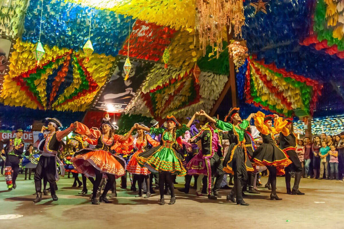 Festa junina em Campina Grande, decorada de bandeiras e pessoas dançando à caráter