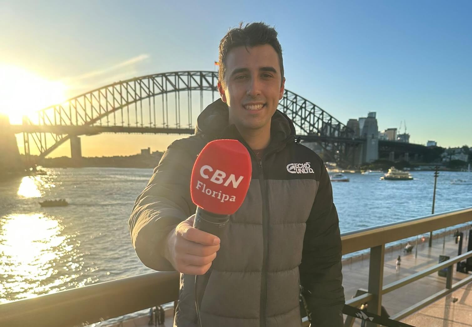 Correspondente da NSC na Austrália, José Walter posa com microfone da CBN Floripa em Sydney