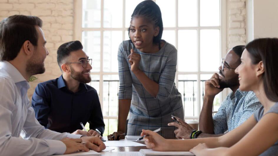 Líder executiva conversando com um grupo de funcionários diversificados