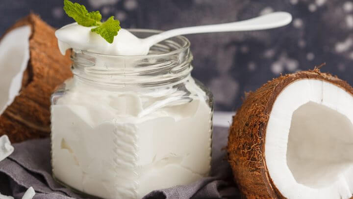 Recipiente branco com requeijão de coco e uma colher