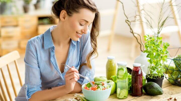 Mulher jovem comendo uma salada